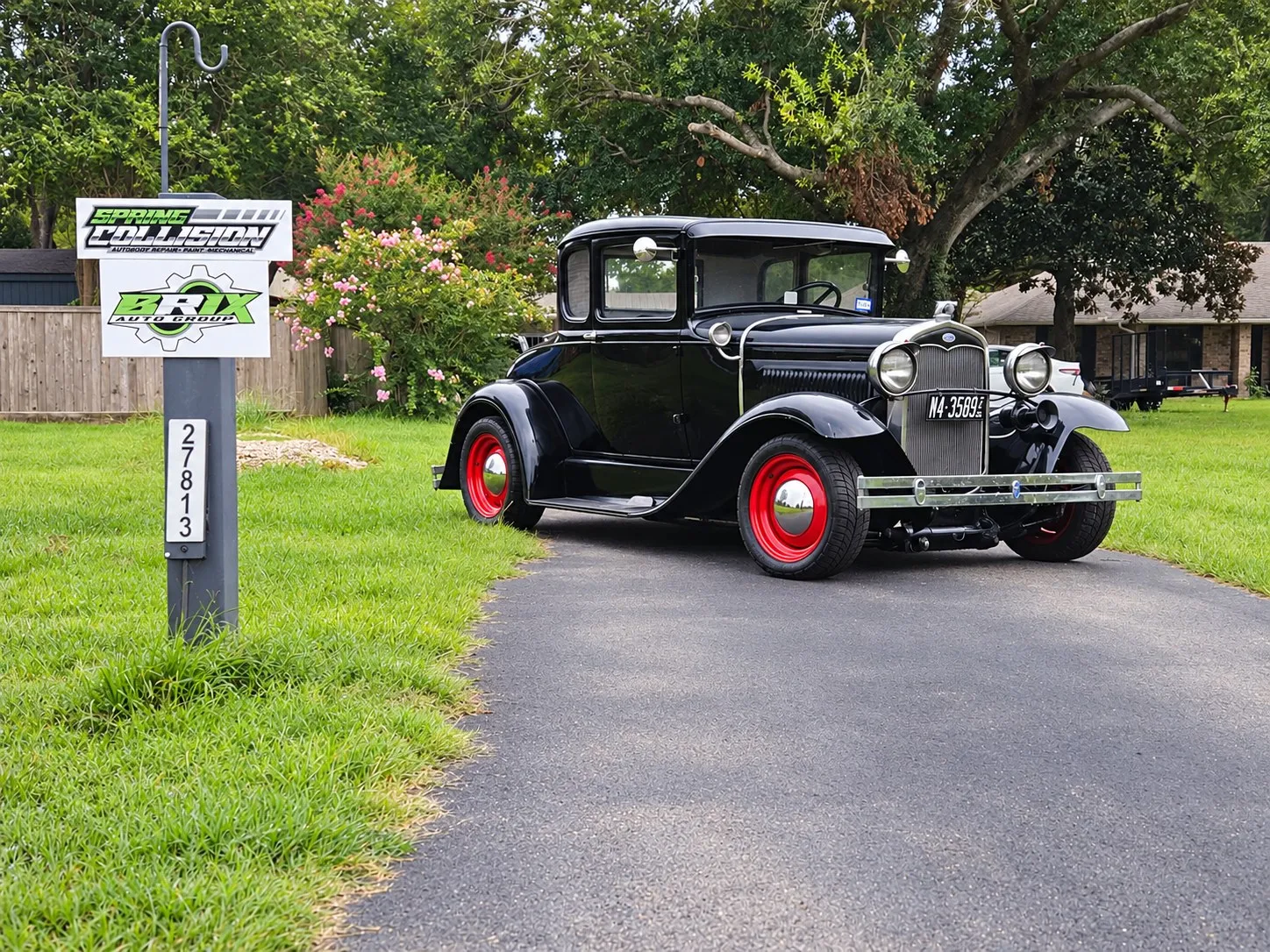 Black Ford Model A coupe with red wheels at Brix Auto on Calvert Rd, Tomball, TX