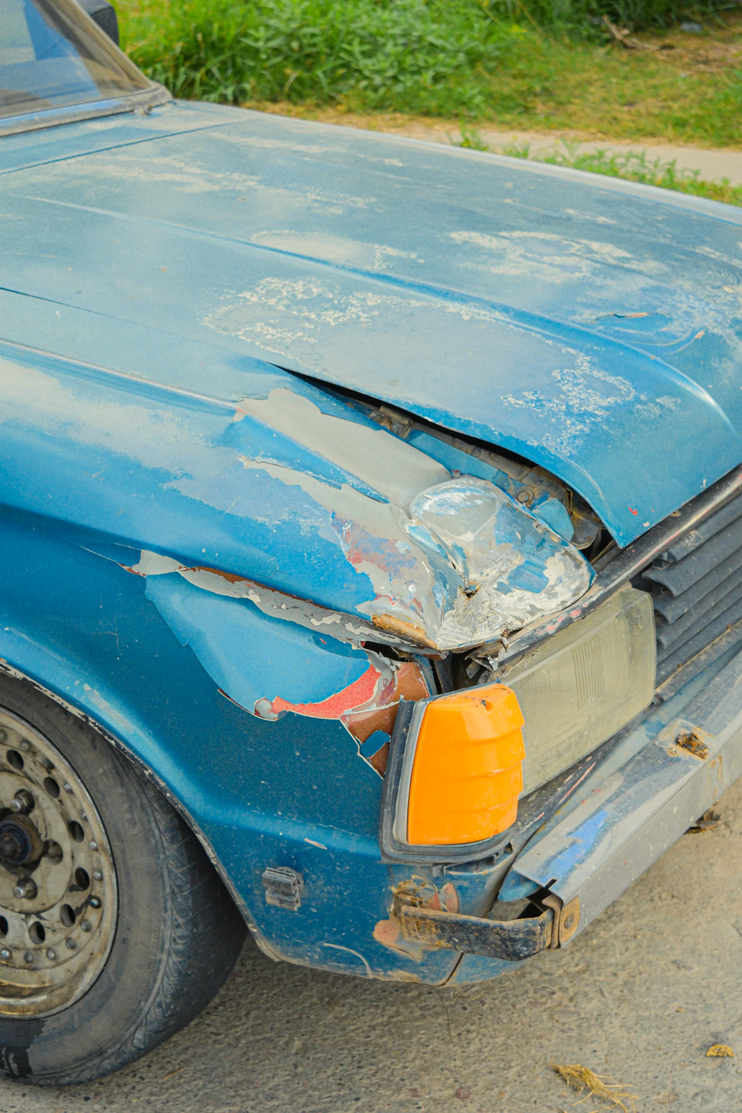 Car with a dented front fender and damaged paint